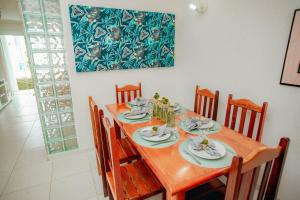 a wooden dining room table with chairs and a painting at Apartamento Duplex Mont Moriá in Porto Seguro