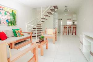a living room with wooden benches and a staircase at Apartamento para família - Duplex Mont Moriá in Porto Seguro