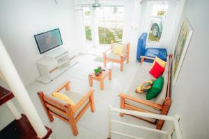 un soggiorno con sedie e TV a schermo piatto di Apartamento Duplex Mont Moriá a Porto Seguro