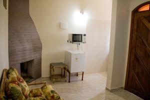 a living room with a couch and a fireplace at Pousada Campestre Estância São Domingos in Serra Negra