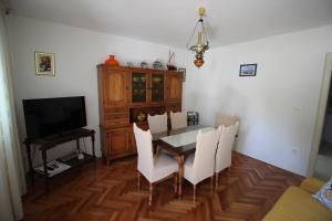 una sala da pranzo con tavolo, sedie e TV di Apartman Antea a Trogir