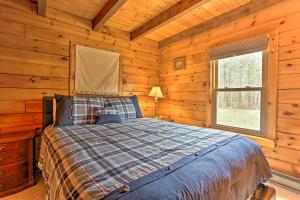 ein Schlafzimmer mit einem Bett in einem Blockhaus in der Unterkunft Pocono Mountains Cabin with Patio, Near Hiking! in East Stroudsburg