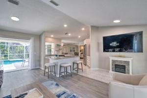 a living room with a kitchen and a fireplace at Modern Home with Screened-In Pool 4 Mi to the Beach in Venice