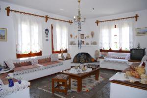 a living room with white couches and a fireplace at Afroditi in Panormos Skopelos