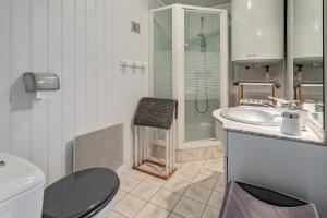 a bathroom with a toilet a sink and a shower at Maison cosy vue mer à Guimaëc in Guimaëc +26 photos