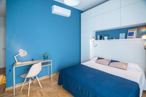 a blue bedroom with a bed and a desk at Locazione turistica a Monterotondo in Monterotondo