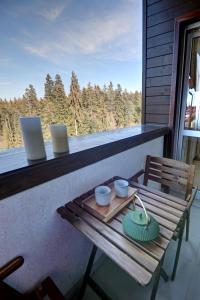 a table on a balcony with a laptop on it at Pinewood Apartment Borovets in Borovets +4 photos