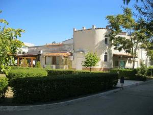 een groot wit gebouw met een heg ervoor bij Apartments Bravo 1-Vichevi in Sunny Beach