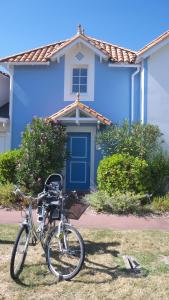 een fiets geparkeerd voor een blauw huis bij Maison Vendée 2ch piscine wifi in Talmont