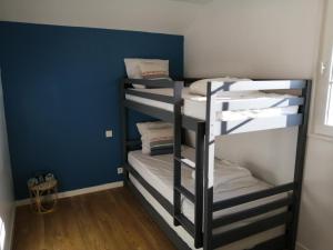 3 stapelbedden in een kamer met een blauwe muur bij Maison Vendée 2ch piscine wifi in Talmont