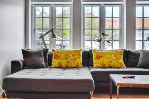 斯卡恩的住宿－1 Skøn og lyst indrettet feriehus i Skagen，客厅配有带黄色枕头的灰色沙发