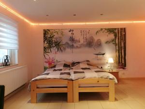 a bedroom with a bed and a painting on the wall at Pension Xiang-Ming in Lohr am Main