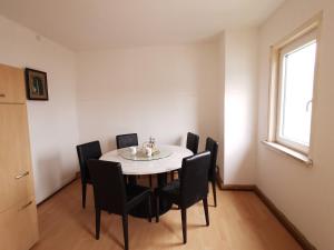 a dining room with a table and black chairs at Pension Xiang-Ming in Lohr am Main