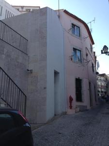 un bâtiment avec un boucher d'incendie rouge à côté d'une rue dans l'établissement Little Alfama Town, à Lisbonne