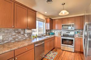 a kitchen with wooden cabinets and stainless steel appliances at Lake McConaughy Getaway with Covered Patio in Belmar