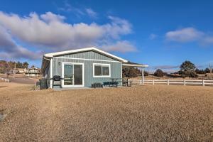 a blue house with a picnic table in a field at Lake McConaughy Getaway with Covered Patio in Belmar