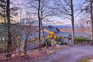 a home in the woods with a fence at Brevard Home with Panoramic Lake and Mountain Views! in Brevard