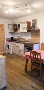 een keuken met een tafel en een fornuis top oven bij Apartment Auszeit mit Küche viel Ruhe und Natur in Untrasried