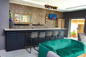 a living room with a bar with a green couch at Mhulu Signature Boutique Hotel in Pretoria