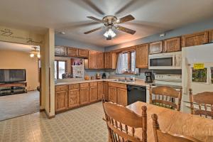 a kitchen with wooden cabinets and a ceiling fan at Waterfront Fond du Lac Home on DeNeveu Lake! in Fond du Lac