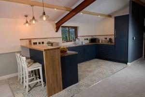 a large kitchen with blue cabinets and a counter at FLANDERS LOFT Luxury Apartment with sauna in Dungiven