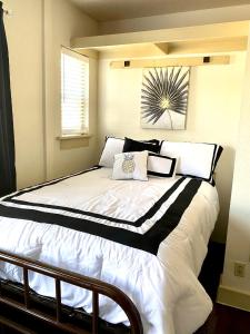 a bedroom with a large bed with black and white pillows at Bright OKC Midtown Studio-Coolest neighborhood in Oklahoma City