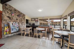 um restaurante com mesas e cadeiras e uma parede de pedra em Econo Lodge Inn & Suites em Hoquiam