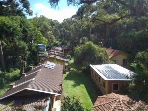 eine Luftansicht eines Hauses mit Sonnenkollektoren auf dem Dach in der Unterkunft Cháles Terra Nativa in Monte Verde
