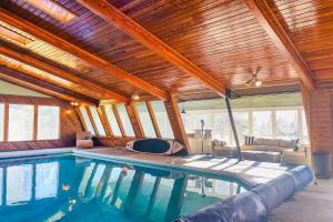 una piscina en una casa con techo de madera en Home with Indoor Pool - 1 Block to Liberty Lake!, en Liberty Lake