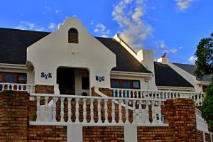 a white house with a black roof at Walkerbay Accommodation in Gansbaai