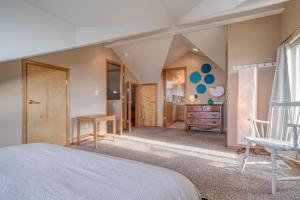 a bedroom with a white bed and a chair at Hubbert Hideaway in Lincoln City