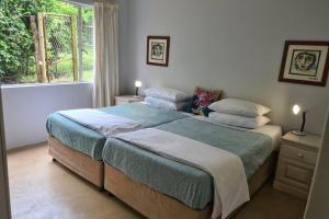 Un dormitorio con una cama grande y una ventana en Hilltop Farm Valley View Cottage, en Henburg Park