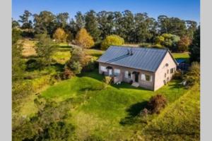 an aerial view of a house on a green field at Hilltop Farm Valley View Cottage in Rosetta