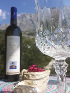 a wine glass sitting next to a bottle of wine at Apartments Stakic in Krvavica