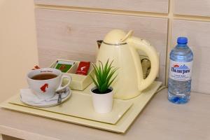 a tray with a tea kettle and a cup of coffee at Ordynka Hotel in Moscow