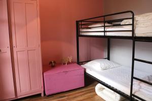 バルスロネットにあるAppartement Barcelonnette centreのベッドルーム1室(二段ベッド2台、ピンクのドレッサー付)