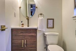a bathroom with a toilet and a sink and a mirror at 6 Mi to Dtwn Austin Home with Screened Porch and Yard in Austin +21 photos