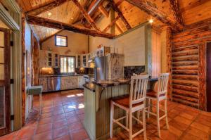 a kitchen with a counter and chairs in a cabin at Luxury Log Cabin Less Than 15 Mi to Downtown Moab! in Moab