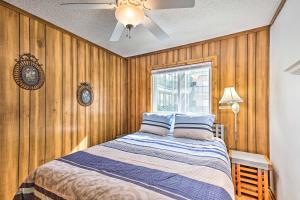 a bedroom with a bed with wooden walls and a window at Beech Mtn Condo w/ Slope View & Resort-Style Perks in Beech Mountain +20 photos