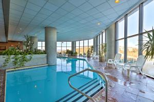 una piscina in un hotel con sedie e finestre di Near Sugar Mountain Renovated Condo with Views! a Sugar Mountain