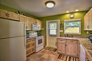a kitchen with wooden cabinets and a white refrigerator at Sunshine State Escape with Bikes, Walk to Beach in Cocoa Beach