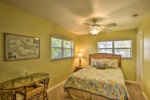 a bedroom with a bed and a table and a ceiling fan at Sunshine State Escape with Bikes, Walk to Beach in Cocoa Beach