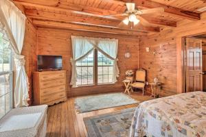 een slaapkamer met een bed, een tv en een raam bij Charming, Rustic Guest Home on 100-Acre Ranch in Rockdale