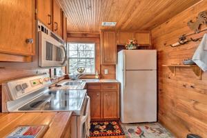 een keuken met houten kasten en een koelkast bij Charming, Rustic Guest Home on 100-Acre Ranch in Rockdale
