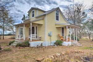 een klein geel huis met twee stoelen op de veranda bij Charming, Rustic Guest Home on 100-Acre Ranch in Rockdale