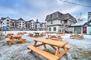 un gruppo di tavoli da picnic in un parco nella neve di Ski-InandSki-Out Getaway at Boyne Mountain Resort a Boyne Falls