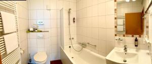 a bathroom with a tub and a toilet and a sink at Altdeutsche Weinstube - Superior in Rüdesheim am Rhein