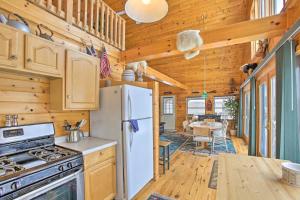 a kitchen with a refrigerator and a dining room at Peaceful Long Lake Cottage with Deck, Dock and Kayaks! in Branch Township