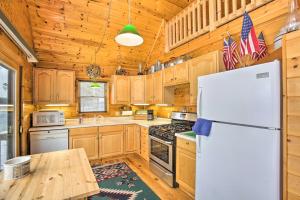 a kitchen with wooden cabinets and a white refrigerator at Peaceful Long Lake Cottage with Deck, Dock and Kayaks! in Branch Township