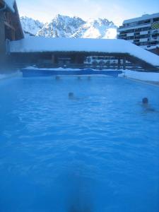 eine Gruppe von Menschen, die in einem Pool im Schnee schwimmen in der Unterkunft Skis aux pieds station 1600 Sun Vallée in Puy-Saint-Vincent